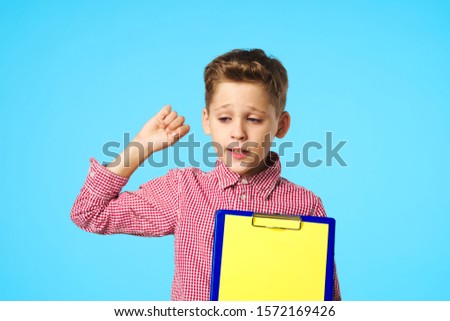 Baby girl in a pink shirt and test folder education documents