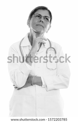 Studio shot of mature beautiful woman doctor thinking while looking up