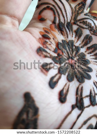 Mehndi art on the hand of young Indian woman. Henna art on woman's hand . Focus on hand