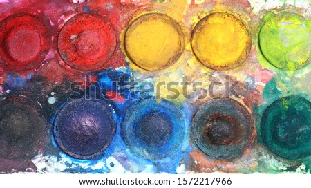 Old watercolor tray mixed with dust, close up,top view.                     Royalty-Free Stock Photo #1572217966