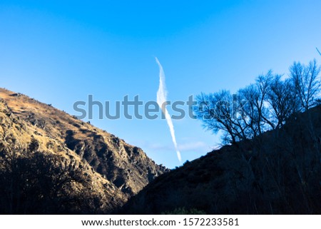 A vertical shaped cloud in between two montains 