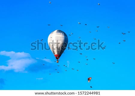 Balloon flies next to parachute . extreme sport . 