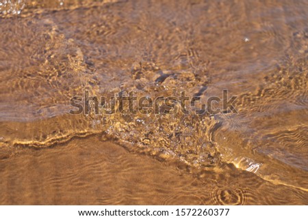 Clean water and orange sand - Kizilkum desert, lake Aydarkul, Uzbekistan.