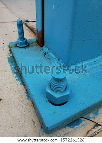 closeup structural support in vivid blue painted heavy duty bolt and nut
