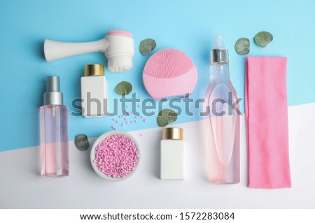 Flat lay composition with face cleansing brushes on color background. Cosmetic accessories
