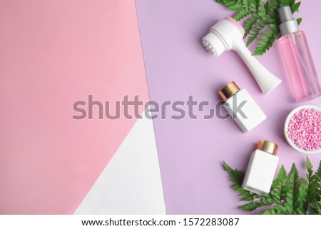 Flat lay composition with face cleansing brush on color background. Cosmetic accessory