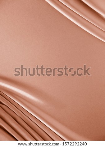 Beautiful smooth elegant wavy beige / light brown satin silk luxury cloth fabric texture, abstract background. Copy space. Card or banner