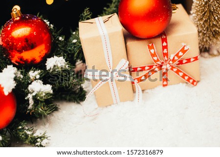 Christmas gift, tree branch and decorations on white wooden table.
