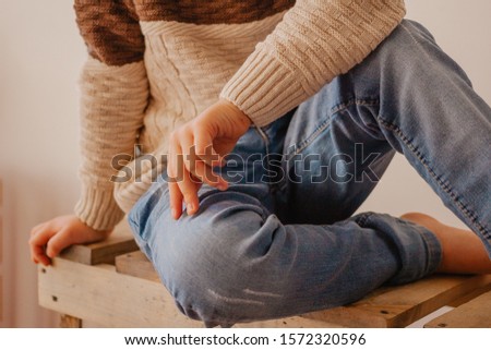 indoor portrait of a boy wearing pullover and jeans