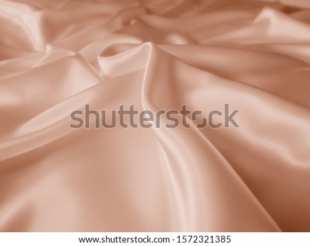 Beautiful smooth elegant wavy beige / light brown satin silk luxury cloth fabric texture, abstract background. Copy space. Card or banner