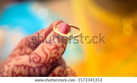 bride with mehandhi hand holding her diamond engagement ring on her finger