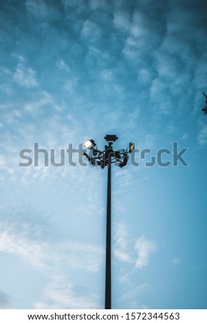 picture of a floodlight pole with a textured sky