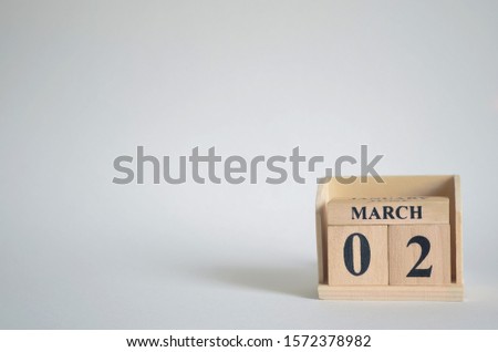 March 2, Empty white background with number cube on the table.