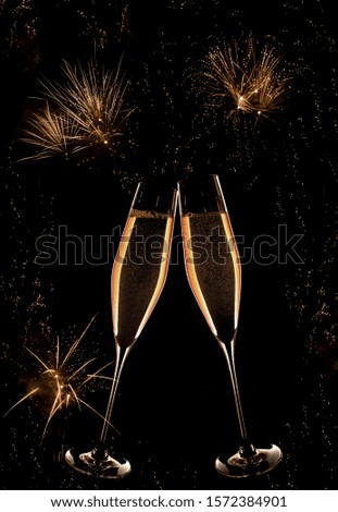 Champagne and golden fireworks on dark night sky at the turn of the year