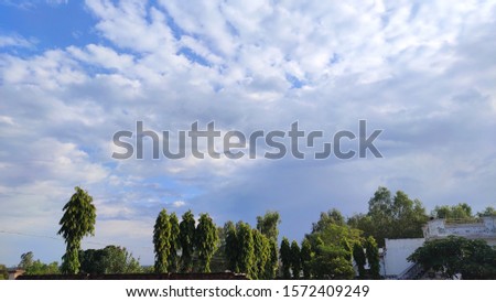it is a picture of beautiful nature trees and clouds.