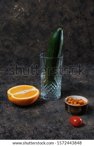 nuts, orange and cucumber in hand