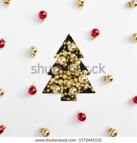 Christmas minimal layout - shape of christmas tree made of golden garland and bauble. Square composition, flat lay, top view. Merry christmas background with red and yellow balls.
