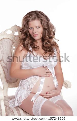 Beautiful Pregnant woman relaxing on the chair isolated over white background