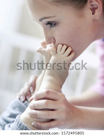 Teenage girl kissing baby's feet