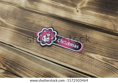 Red sticker with Christmas illustration on wooden background