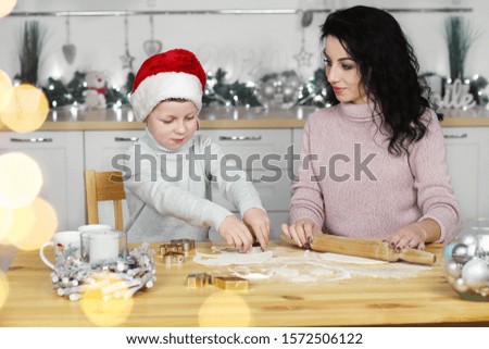 happy family mother and son bake cookies for Christmas. Mother and son making Christmas cookies and having fun.Merry christmas and new year.Mother and son prepare New Year cookies in the kitchen