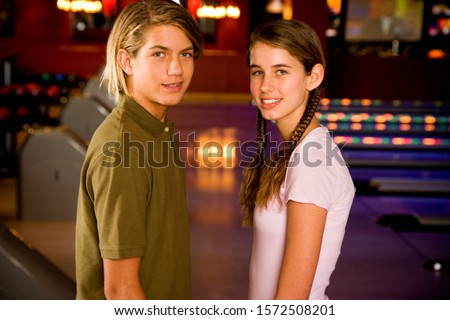 Teenage boy and girl in a bowling alley