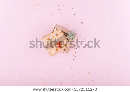 Gift boxes on a stylish pink background with gold sequins. Concept for Christmas or new year. Flat lay