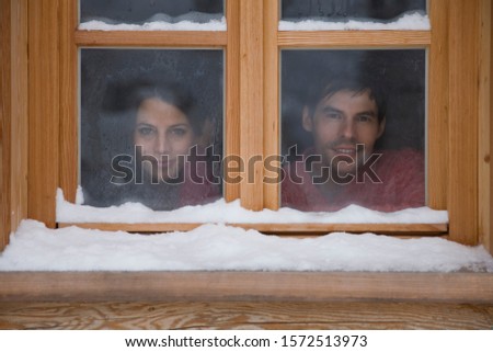 Mid adult couple looking through window