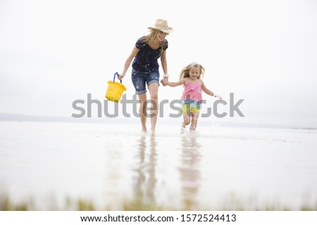 Mother and daughter walking in water