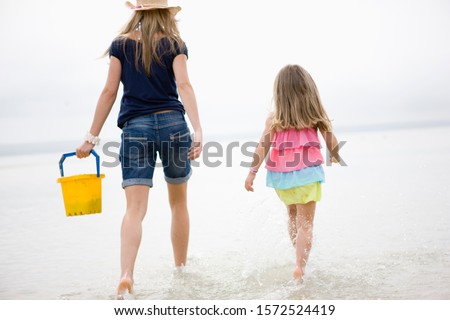 Mother and daughter walking in water