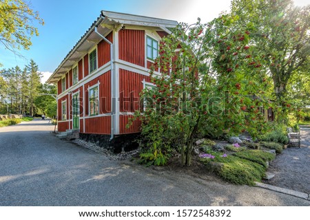 A traditional white and red painted wooden house building in Skansen open-air museum at sunny autumn day. Stockholm, Sweden.