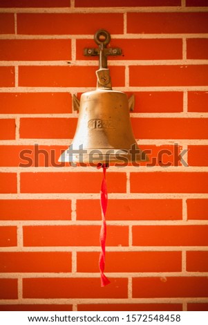 Bell mounted on brick wall with inscription 1842