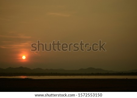 Natural Sunset  Over Field. Bright Dramatic Sky And Dark Ground. Countryside Landscape Under Scenic Colorful Sky At Sunset .