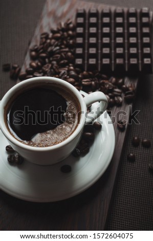 cup of aromatic coffee near coffee beans and chocolate