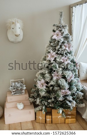 Christmas atmosphere, fir tree decorated with toys, and gifts.
