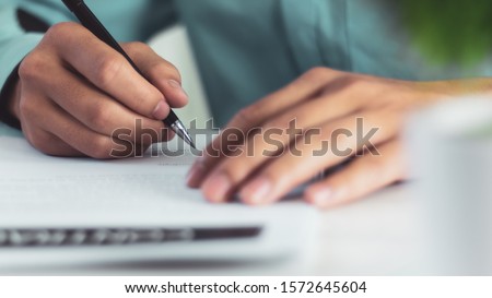 Businessman signing a document after reading the agreement in office Royalty-Free Stock Photo #1572645604