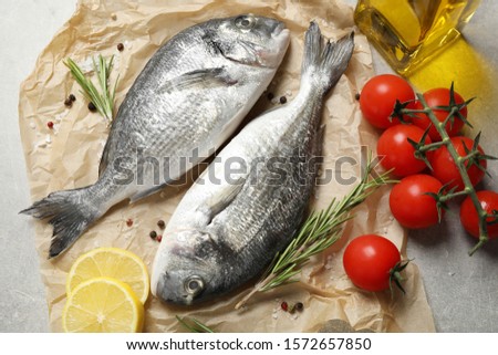 Flat lay composition with raw dorada fish on table