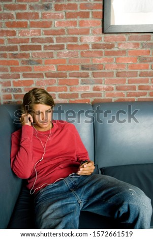 Teenage boy on a seat listening to music on mp3