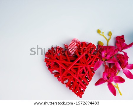 Background with flowers and decorative red heart in ray of light on blue. Selective focus is on heart. Place for text. Valentine's day, mom, love and holiday, card.