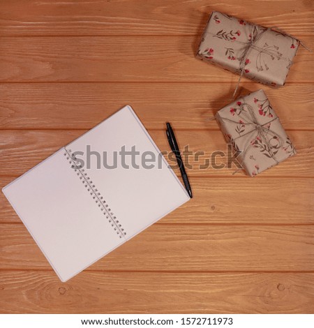 gifts boxes and notebook on wooden background, tot view, flat lay