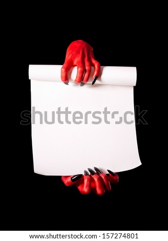 Red devil hands holding paper scroll, deal with devil concept, isolated on black background 