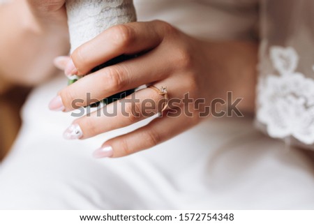 Bride's hand close up with a minimalistic engagement ring with a diamond