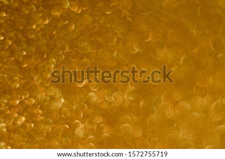 Abstract Christmast golden bokeh background with shining defocus sparkles. Blurred glitters shimmering dust macro close up, copy space for text logo