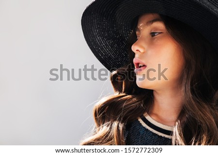Girl child in a hat at the photo Studio.Girl model