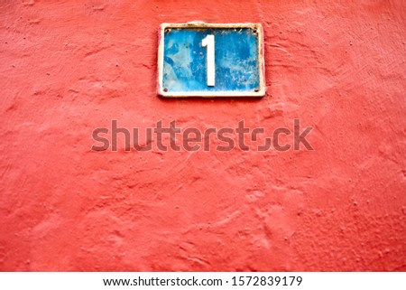 Number 1, one, blue plate on a joyful pink background.