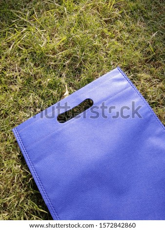 isolated blue d cut Non Woven Polypropylene Bag on grass