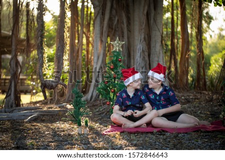 Lovely relaxed Christmas portrait with two brothers in cheerful holiday outfits