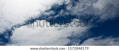 Hazy fluffy clouds with some cumulostratus and cirrus formations on an early spring afternoon are contrasted against the azure blue Australian sky creating a fascinating cloud scape.