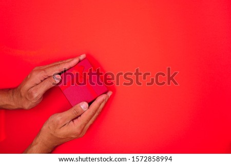 Happy New Year and Christmas 2020 or valentine day, top view hands with red gift box on red background with copy space for your text