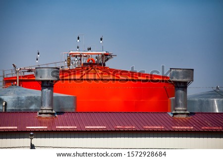 Orange steel storage tanks with acid at sulfuric acid plant warehouse. Close-up side view